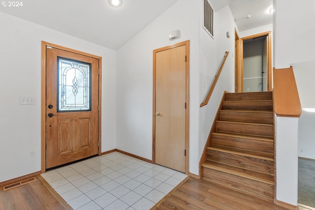 foyer with light hardwood / wood-style floors and lofted ceiling