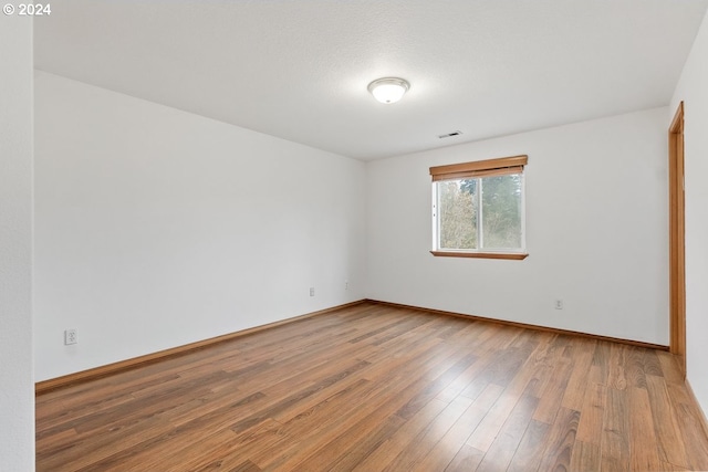 spare room with hardwood / wood-style flooring and a textured ceiling