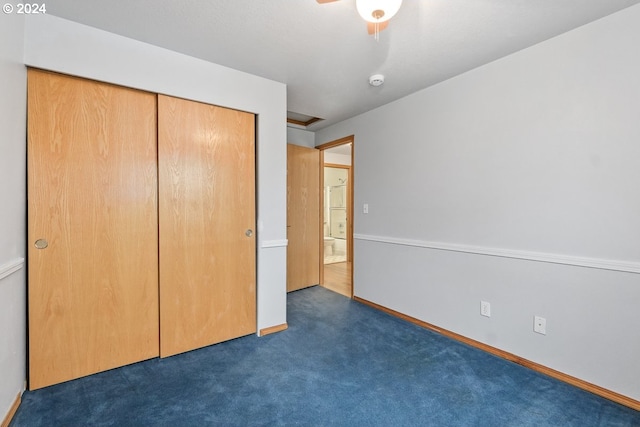 unfurnished bedroom featuring a closet and dark colored carpet