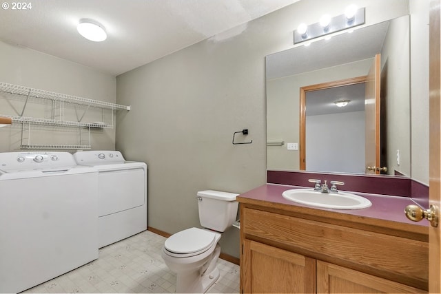 bathroom with vanity, washer and dryer, and toilet