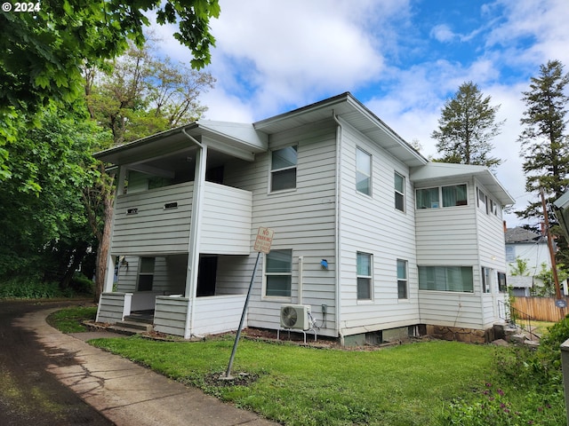 exterior space with ac unit and a front yard