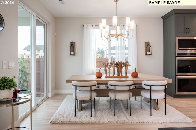 dining space featuring light hardwood / wood-style flooring, a wealth of natural light, and a notable chandelier