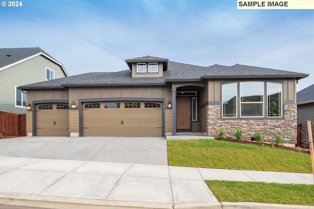 prairie-style house featuring a front lawn and a garage