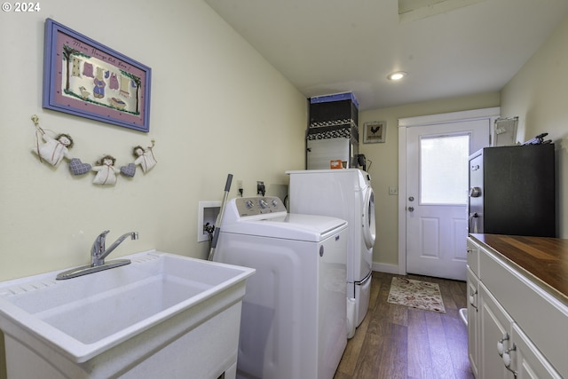 laundry area with washer and dryer, dark hardwood / wood-style flooring, cabinets, and sink