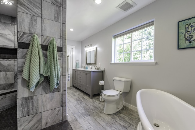 bathroom featuring a bathing tub, vanity, and toilet