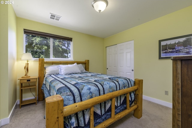 bedroom featuring light colored carpet and a closet