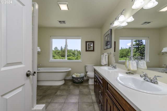 bathroom featuring tile patterned floors, vanity, toilet, and a bath