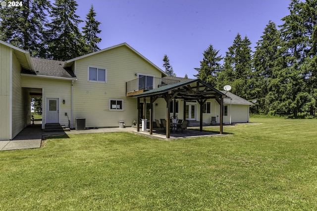 back of property with a yard, a balcony, cooling unit, and a patio area