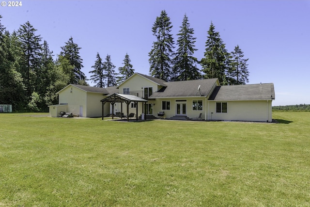 rear view of property featuring a gazebo, a patio area, and a lawn