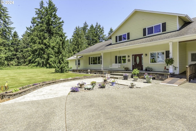 farmhouse-style home featuring covered porch and a front lawn