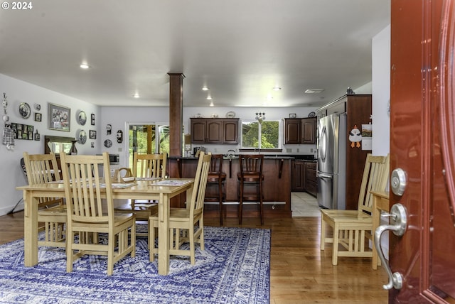 dining room featuring light hardwood / wood-style floors and ornate columns