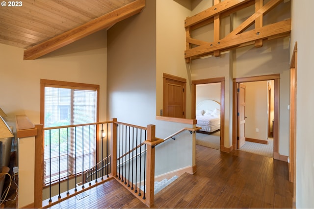 hall with wood ceiling, beamed ceiling, high vaulted ceiling, and dark wood-type flooring