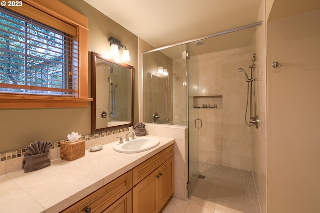 bathroom featuring tile patterned flooring, a shower with shower door, and vanity