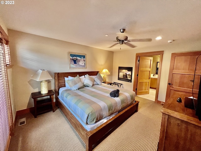 carpeted bedroom with ceiling fan and ensuite bathroom