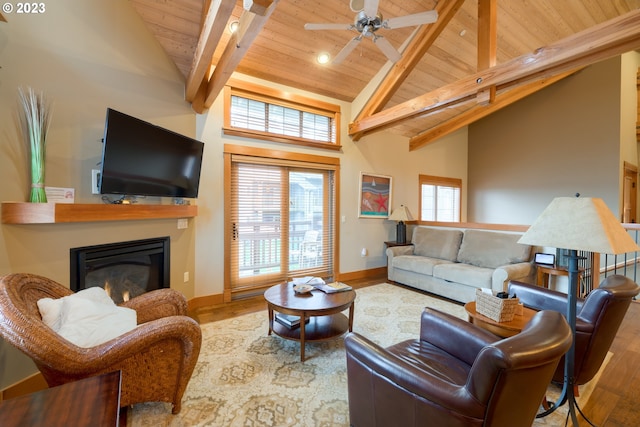 living room featuring ceiling fan, beam ceiling, wood-type flooring, high vaulted ceiling, and wooden ceiling