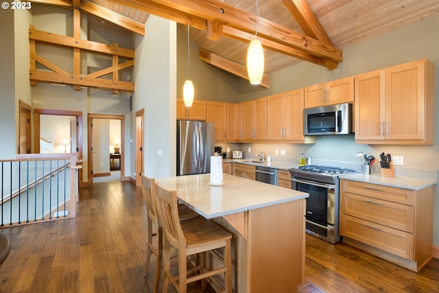 kitchen with dark hardwood / wood-style floors, beam ceiling, light brown cabinets, appliances with stainless steel finishes, and decorative light fixtures