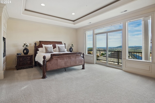 bedroom featuring a raised ceiling, access to exterior, a mountain view, ornamental molding, and light colored carpet