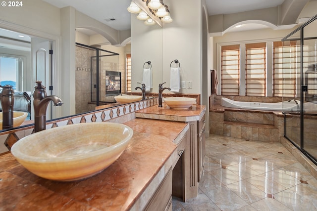 bathroom featuring vanity and independent shower and bath