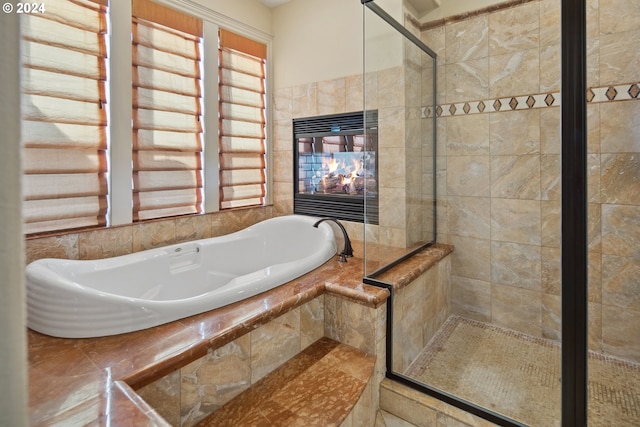 bathroom featuring independent shower and bath and tile walls