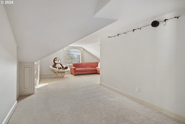 unfurnished bedroom featuring light carpet and lofted ceiling