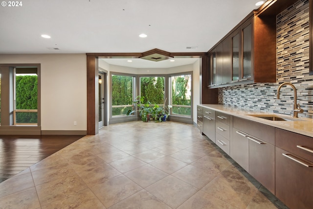 kitchen with light hardwood / wood-style flooring, sink, a wealth of natural light, and backsplash