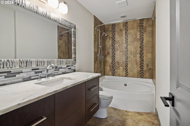 full bathroom with tile patterned floors, decorative backsplash, toilet, tiled shower / bath, and vanity