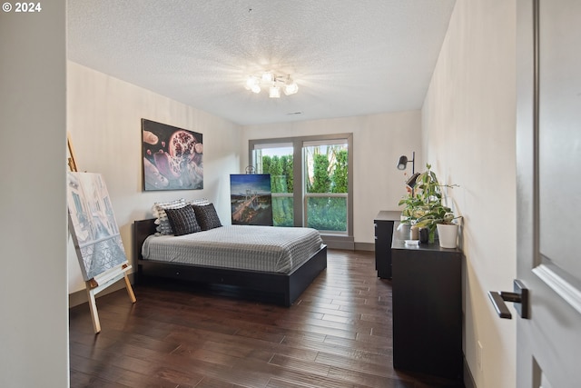 bedroom with dark wood-type flooring and a textured ceiling