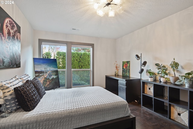 bedroom featuring a textured ceiling and dark hardwood / wood-style flooring