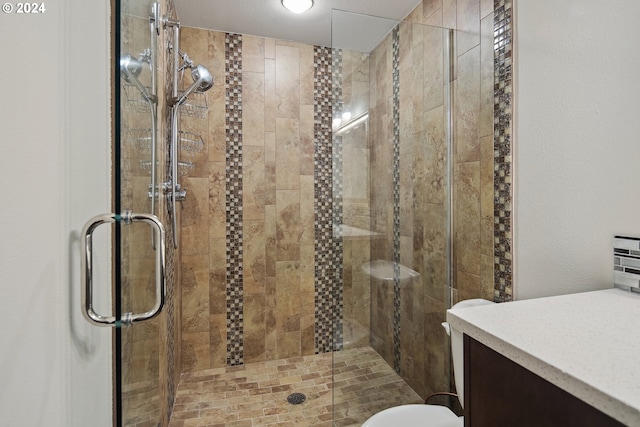 bathroom with a shower with door, toilet, and vanity