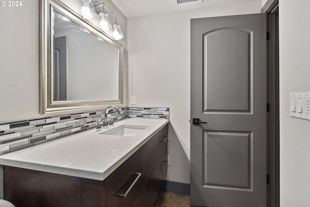 bathroom featuring vanity and backsplash