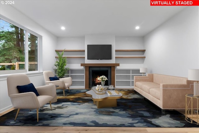 living room featuring a tile fireplace and wood-type flooring