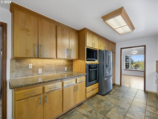 kitchen featuring appliances with stainless steel finishes, dark stone counters, and decorative backsplash