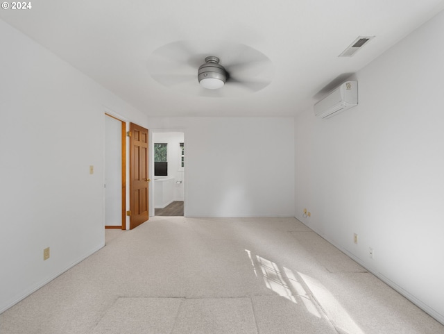 spare room with light carpet, a wall mounted AC, and ceiling fan