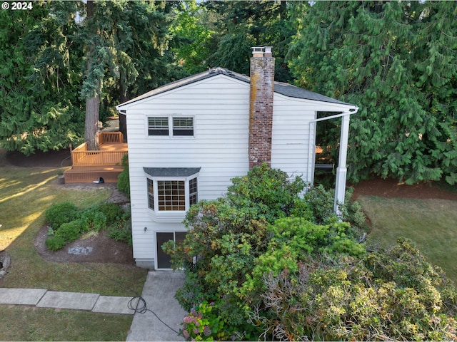 view of side of home featuring a wooden deck and a yard