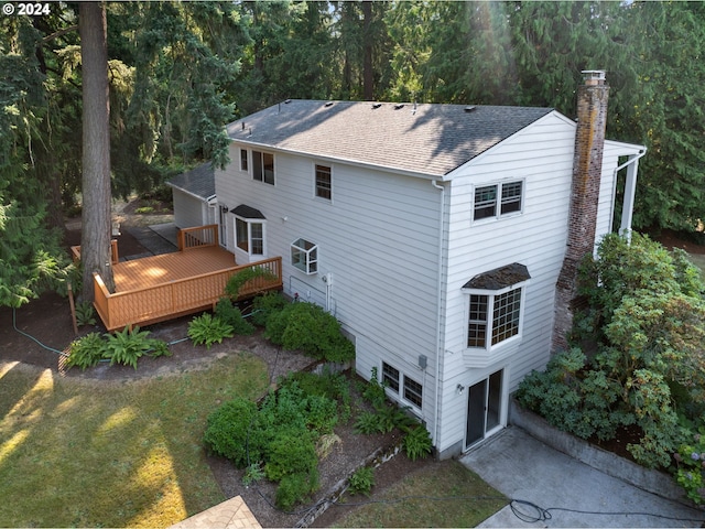 rear view of house with a wooden deck and a yard