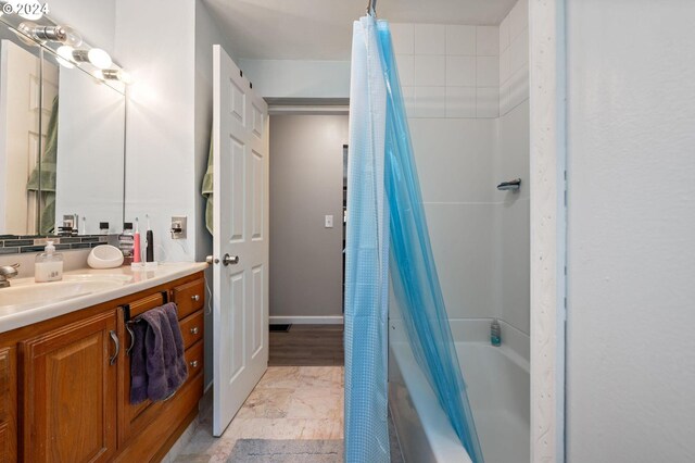 bathroom with shower / tub combo with curtain, vanity, and tile patterned flooring