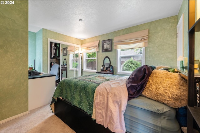 bedroom with a closet, carpet floors, and a textured ceiling