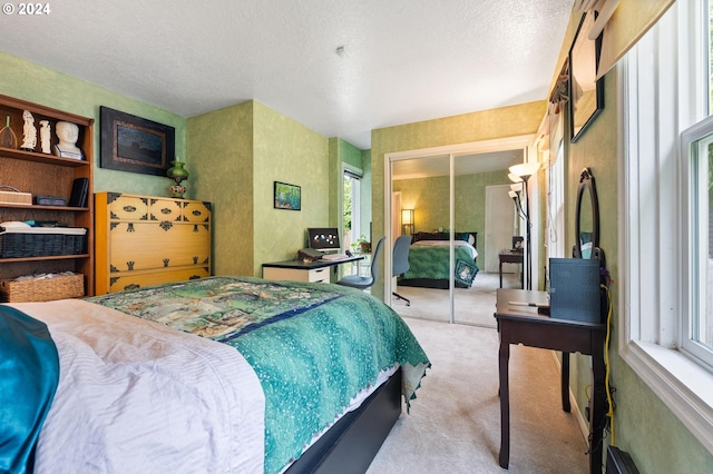 bedroom with a closet, a textured ceiling, and light colored carpet