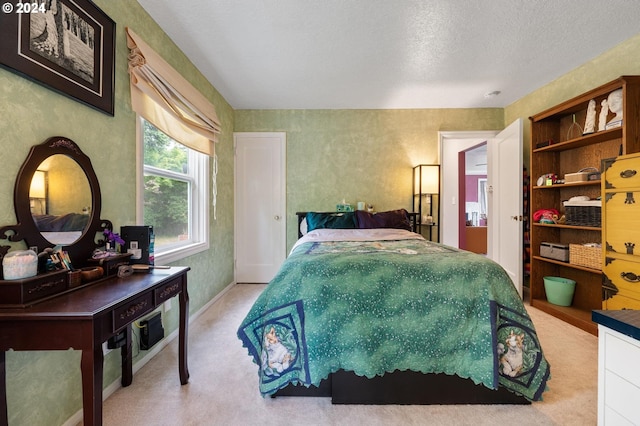 bedroom with a textured ceiling and light colored carpet