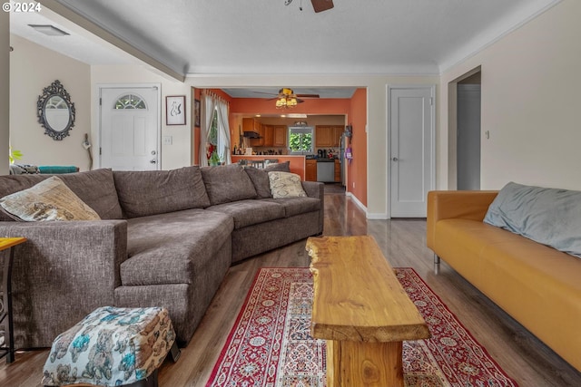 living room featuring ceiling fan and dark wood-type flooring