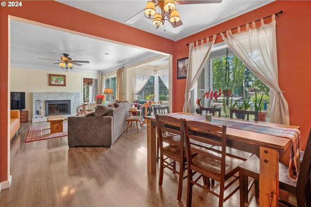 dining room featuring light hardwood / wood-style floors, a fireplace, and ceiling fan