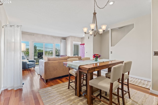 dining area with light wood-style flooring, recessed lighting, baseboards, and a chandelier