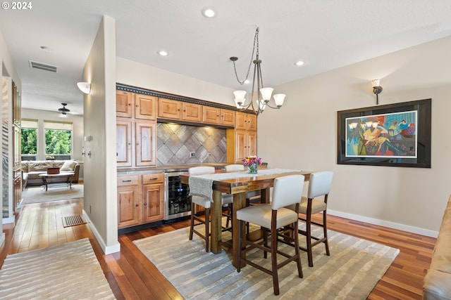 dining area featuring beverage cooler, visible vents, baseboards, and hardwood / wood-style flooring