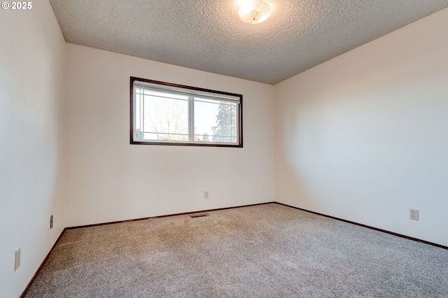 spare room featuring carpet flooring and a textured ceiling