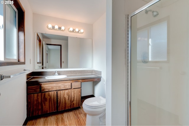 bathroom with vanity, hardwood / wood-style floors, toilet, and an enclosed shower