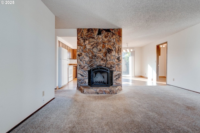 unfurnished living room featuring light colored carpet, a stone fireplace, a chandelier, and a textured ceiling