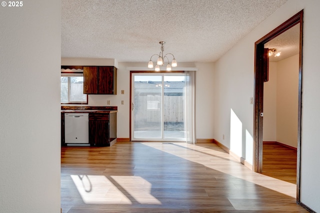 kitchen with a chandelier, hanging light fixtures, white dishwasher, a textured ceiling, and light hardwood / wood-style flooring