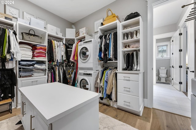 walk in closet featuring light hardwood / wood-style floors and stacked washer and dryer