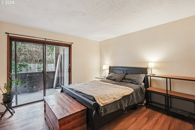 bedroom with access to outside, a textured ceiling, and hardwood / wood-style floors