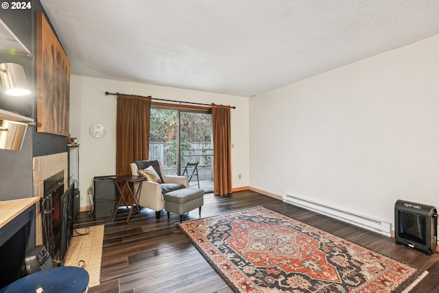 living area with a baseboard radiator, a textured ceiling, a fireplace, and dark hardwood / wood-style floors